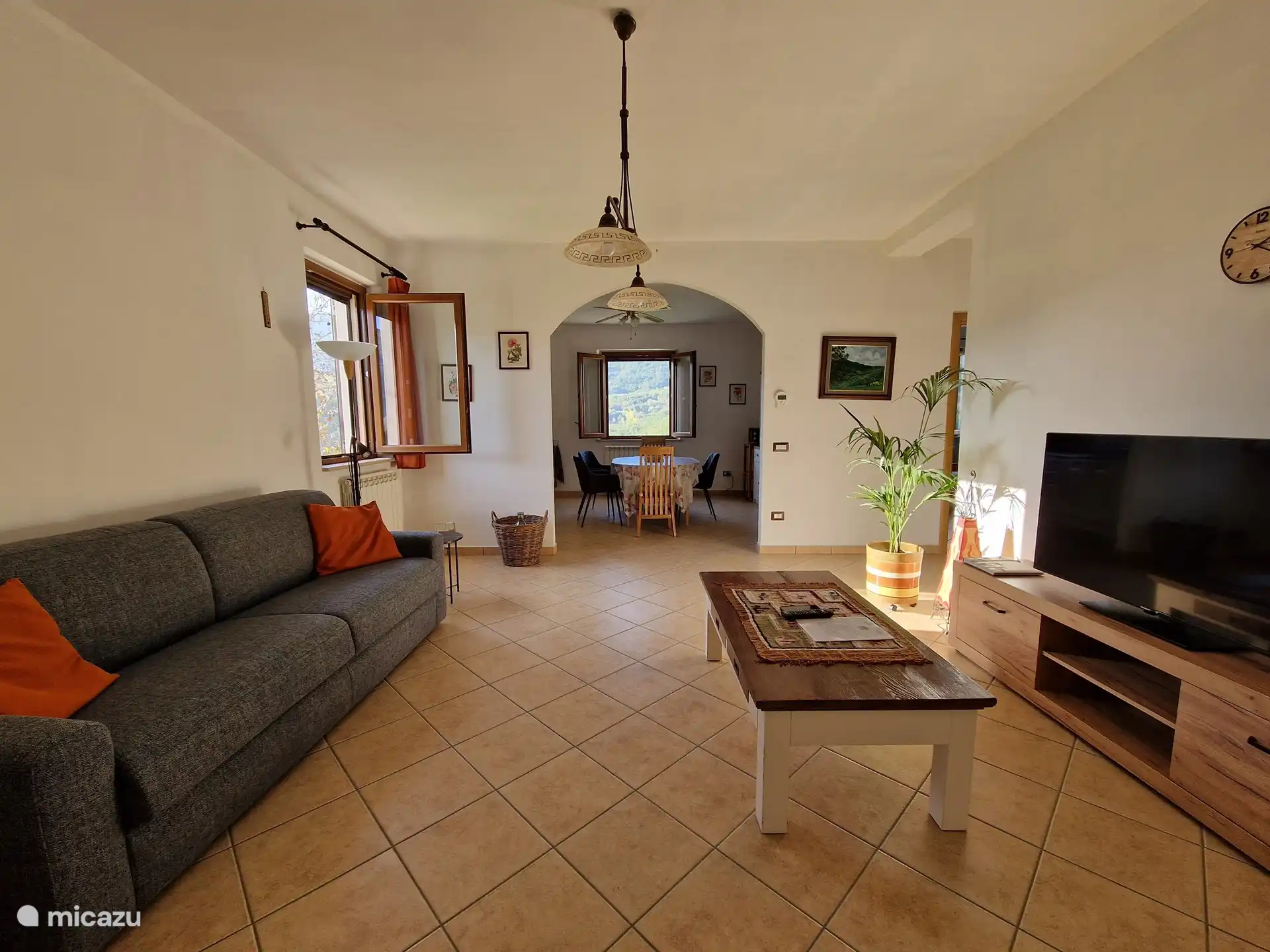 The living room with sitting area and a view of the kitchen.
