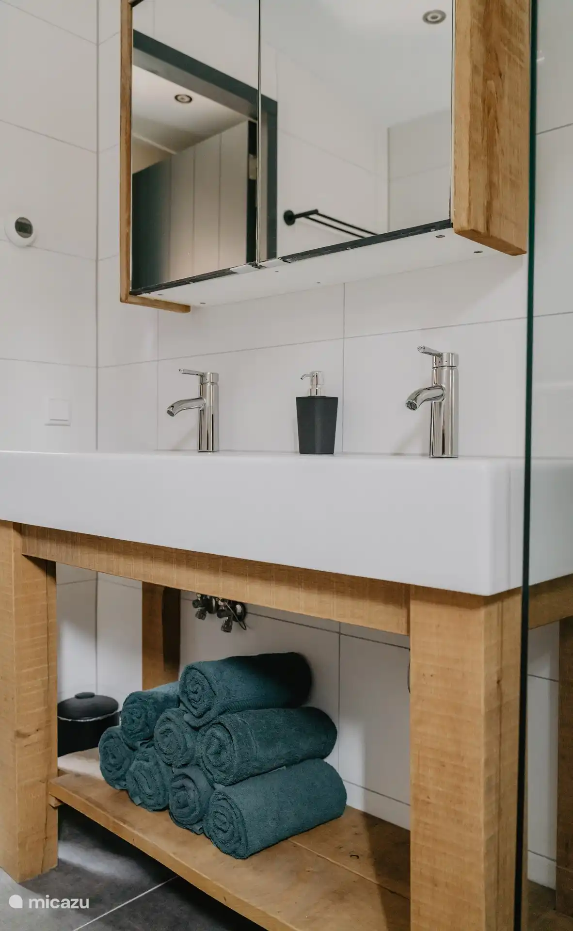 Le mobilier de la salle de bain est équipé d’une armoire de toilette avec espace de rangement