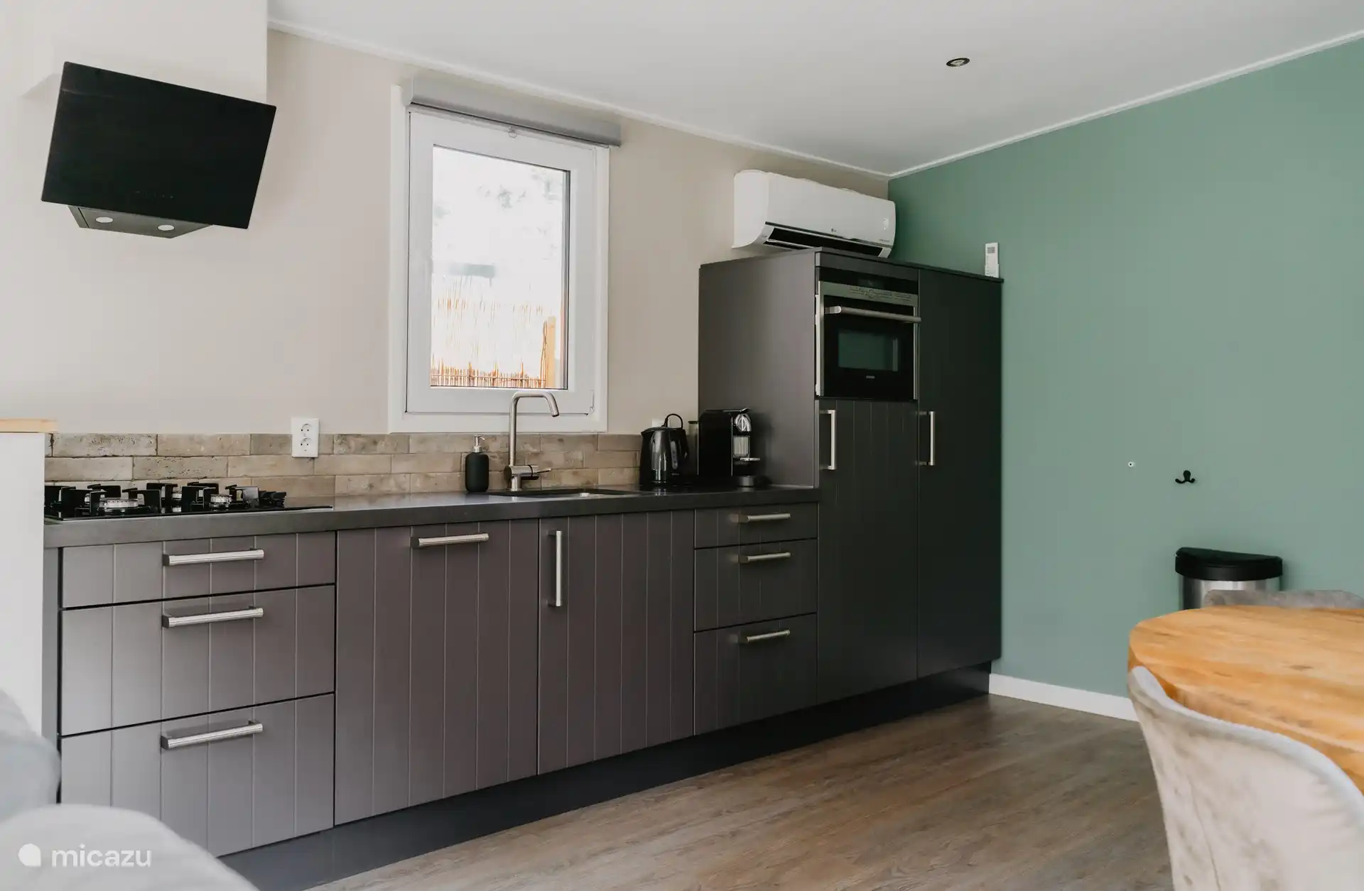 La vaste cuisine est équipée d’un réfrigérateur avec congélateur, d’un micro-ondes combiné, d’un lave-vaisselle, d’une cuisinière à gaz à 4 feux et d’une hotte aspirante.