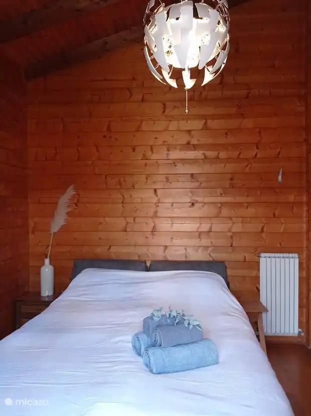 Schlafzimmer mit Doppelbett neben Balkon