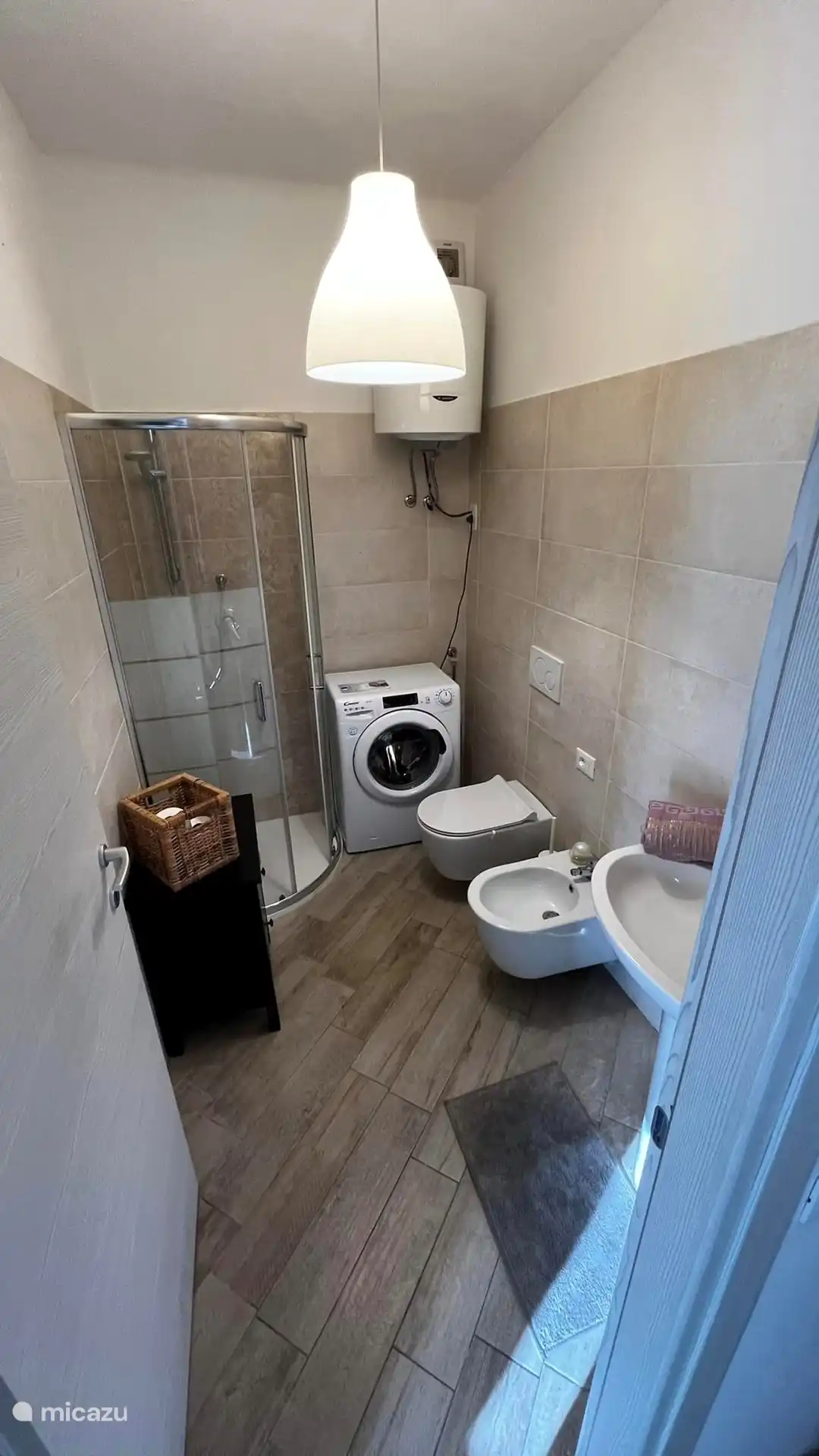 Badezimmer mit Dusche, WC, Bidet, Waschbecken, Waschmaschine.