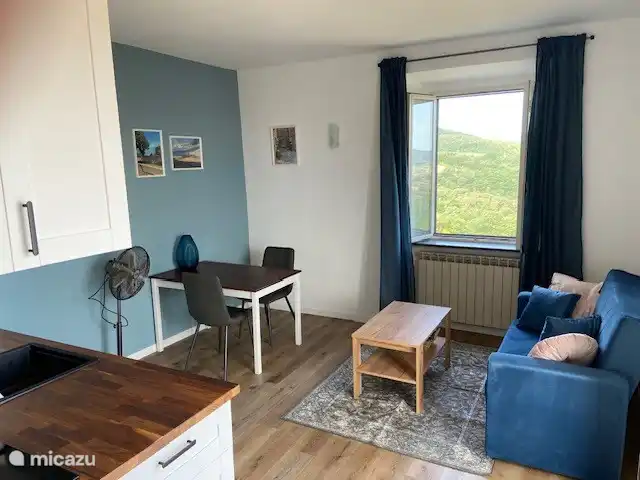 Das Wohn-/Esszimmer verfügt über ein Sofa und einen Esstisch.