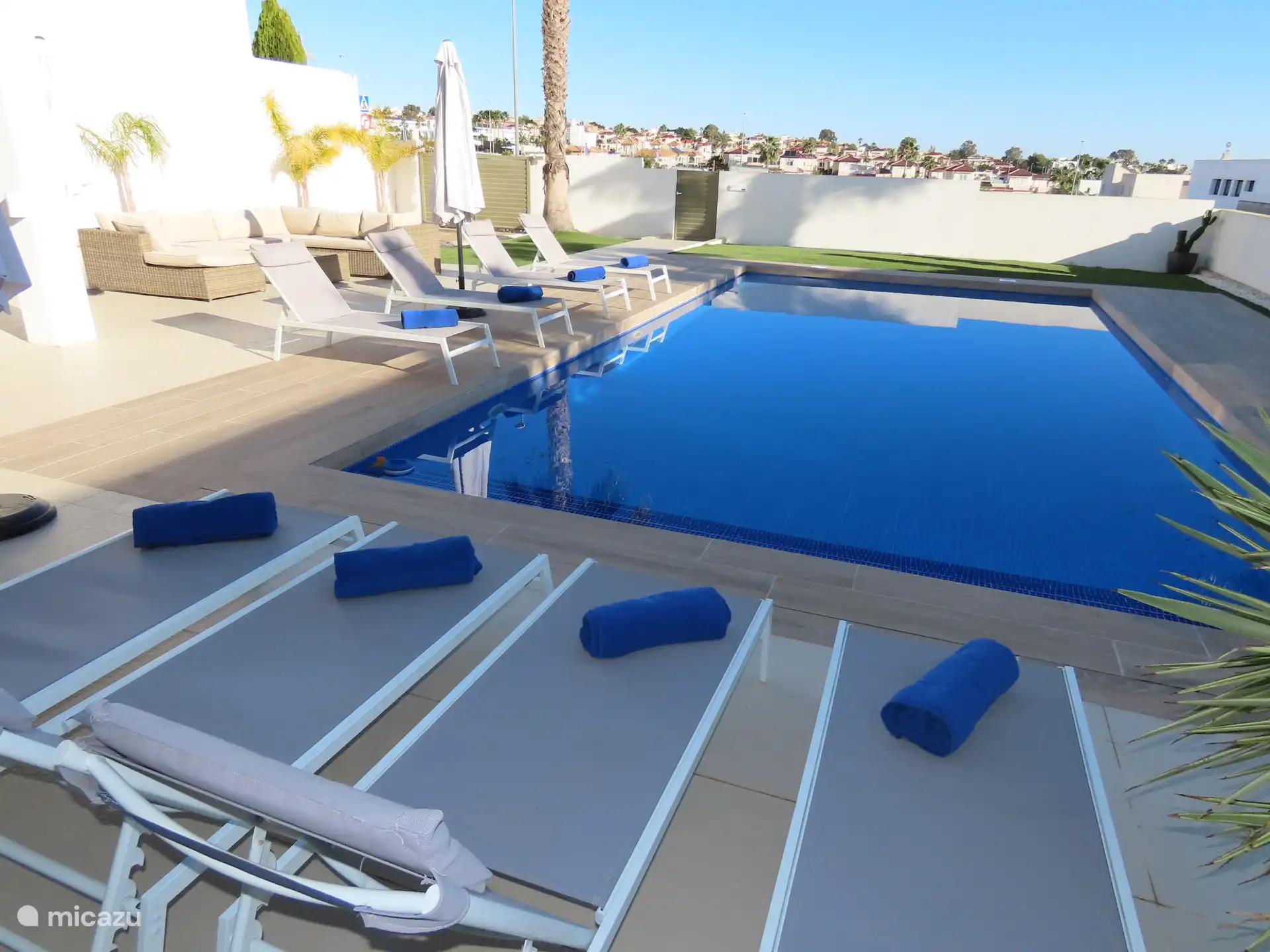 Groot privé zwembad met ligbedden en vernieuwd terras.