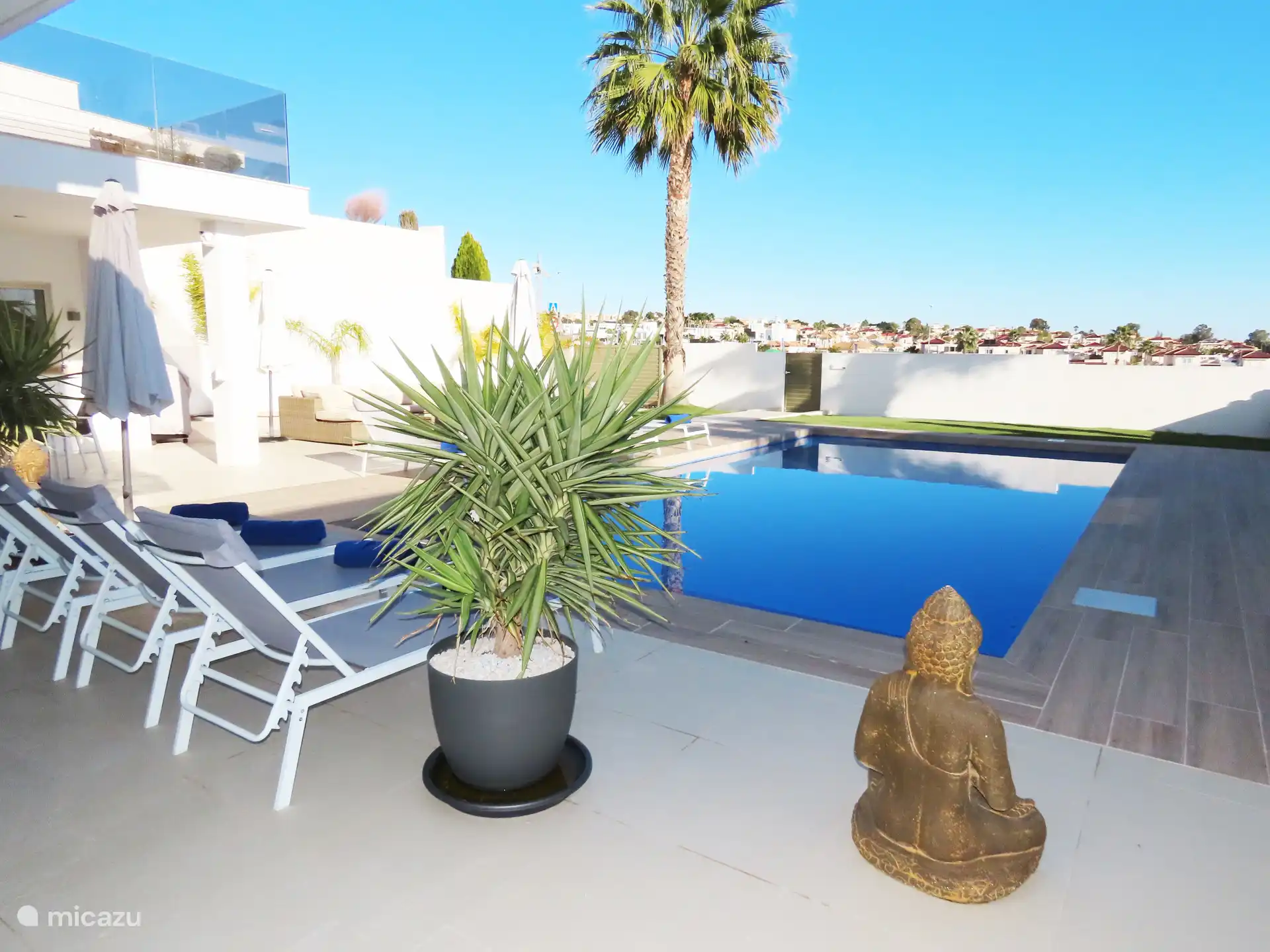 Groot privé zwembad met ligbedden en sfeervol vernieuwd terras.