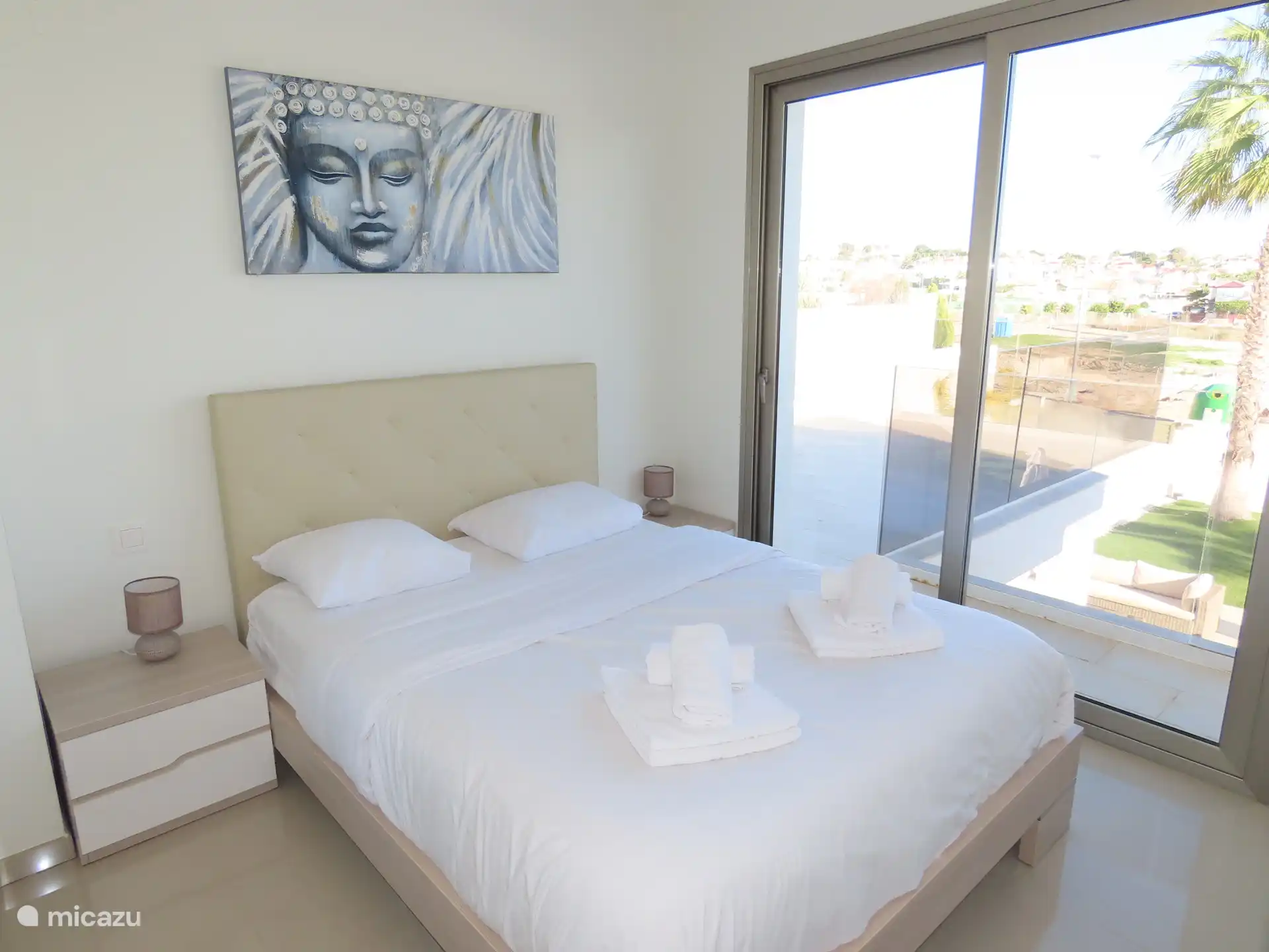 Slaapkamer met automatische blindering (type luxaflex) aangrenzend terras