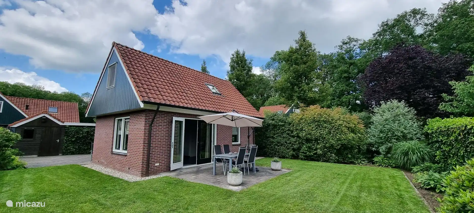 Schöner Garten mit Gartentisch mit 6 Stühlen und schwimmendem Sonnenschirm