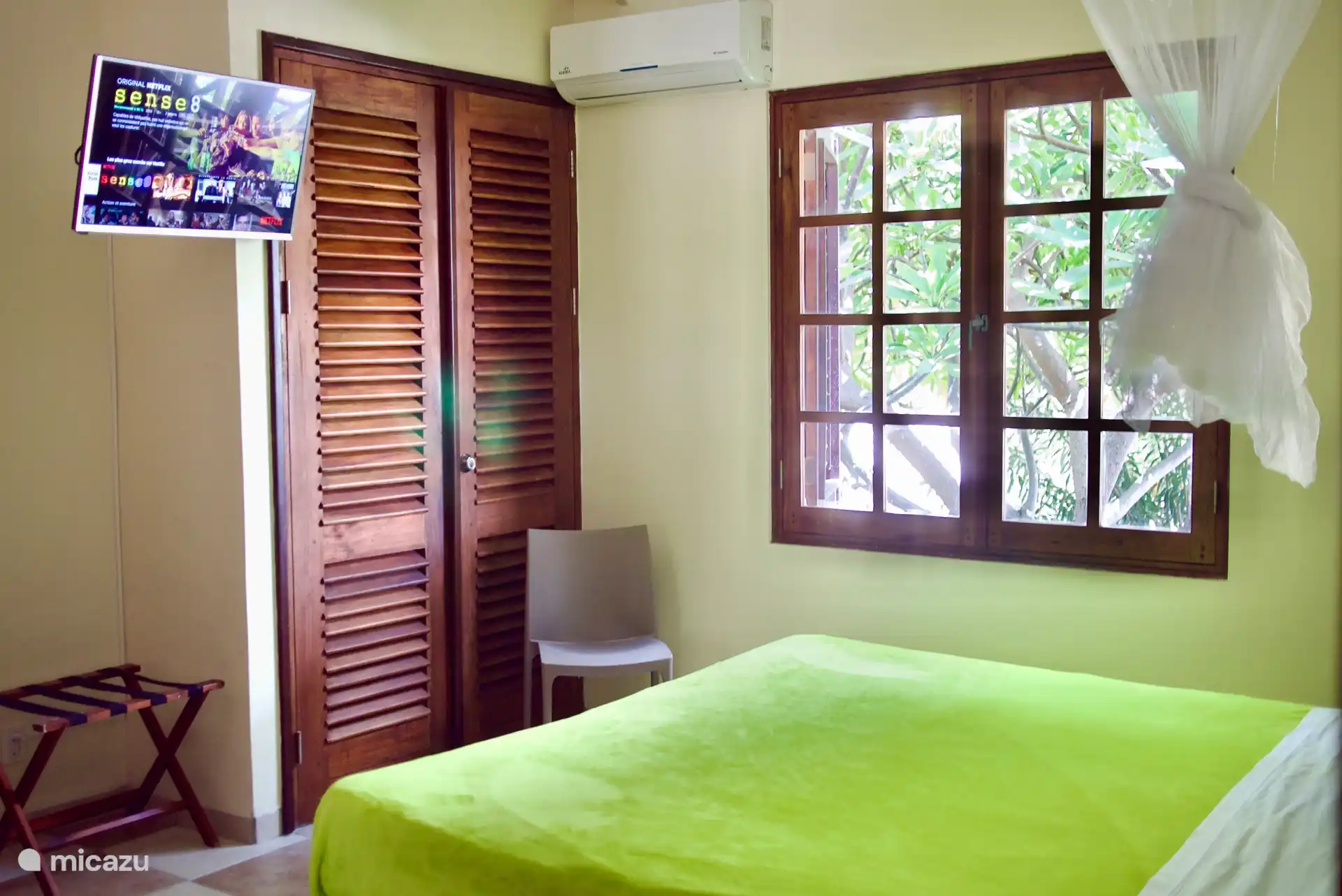 Primer dormitorio con aire acondicionado, ventilador, TV y baño privado