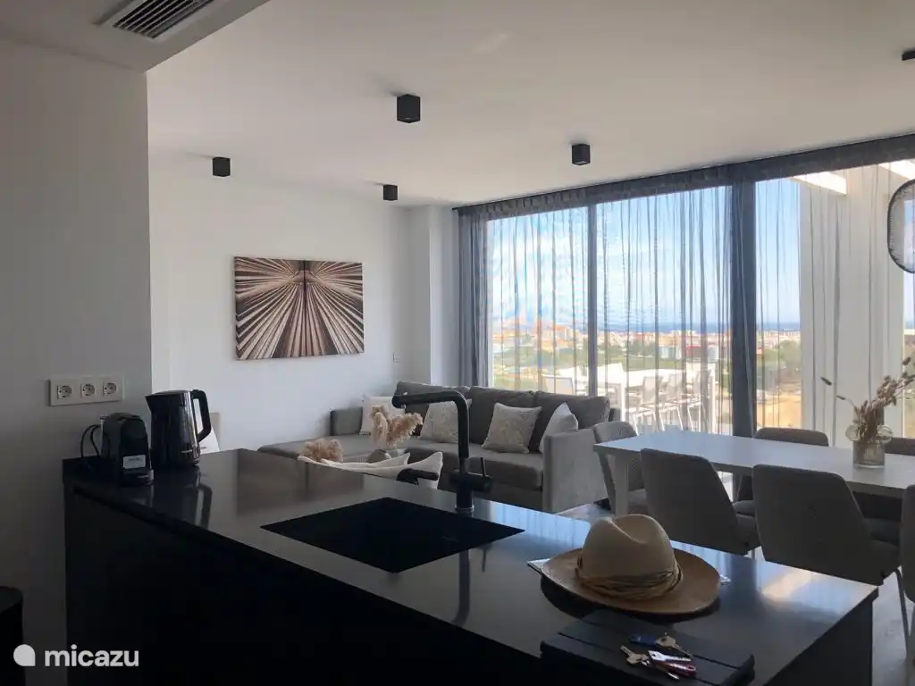 Wohnzimmer mit Küche, Schiebetüren zum Balkon und Meerblick 