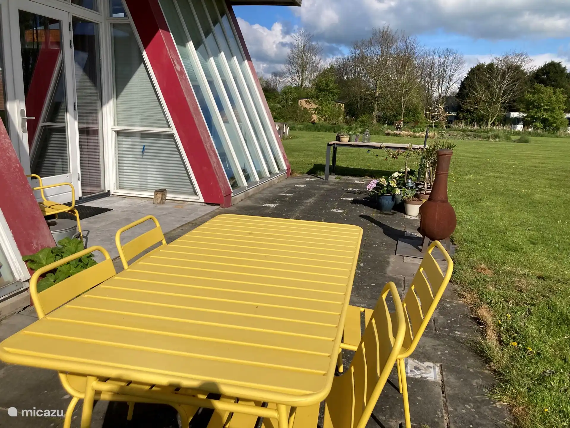 Unsere Terrasse mit einem fröhlichen Gartentisch mit 6 Esszimmerstühlen. Im Schuppen stehen noch 3 weitere bequeme Gartenstühle. Dort finden Sie auch den Grill. Wir arbeiten immer noch an einer Außenküche