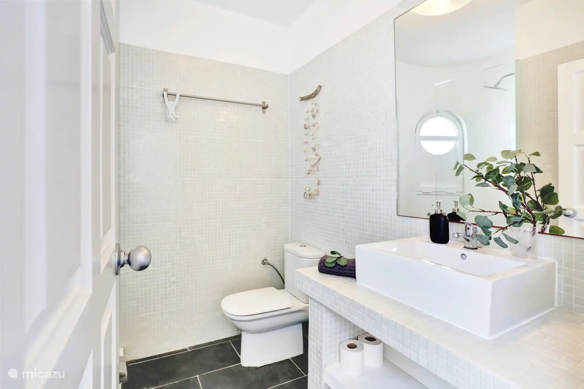 Badezimmer mit Dusche, Waschbecken und Toilette.