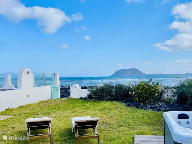 The Beach House (nouvelle inscription) | Espagne, Fuerteventura, Corralejo - maison de vacances Le grand jardin (avec jacuzzi) offre une vue directe sur la mer et les îles de Lobos et Lanzerote. C'est le plus beau, sinon l'un des plus beaux endroits où séjourner à Fuerteventura !