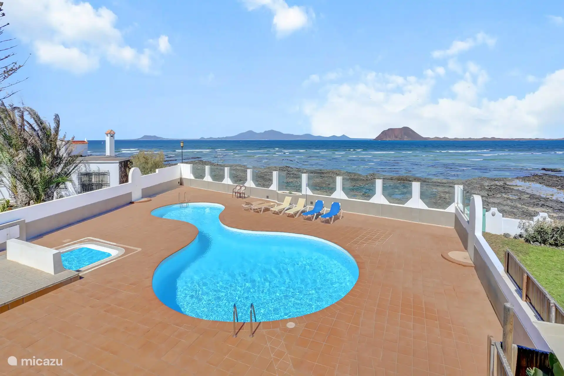 Hinter dem Schwimmbad sehen Sie rechts die Insel Lobos und links Lanzerote (nur 20 Minuten mit der Fähre)