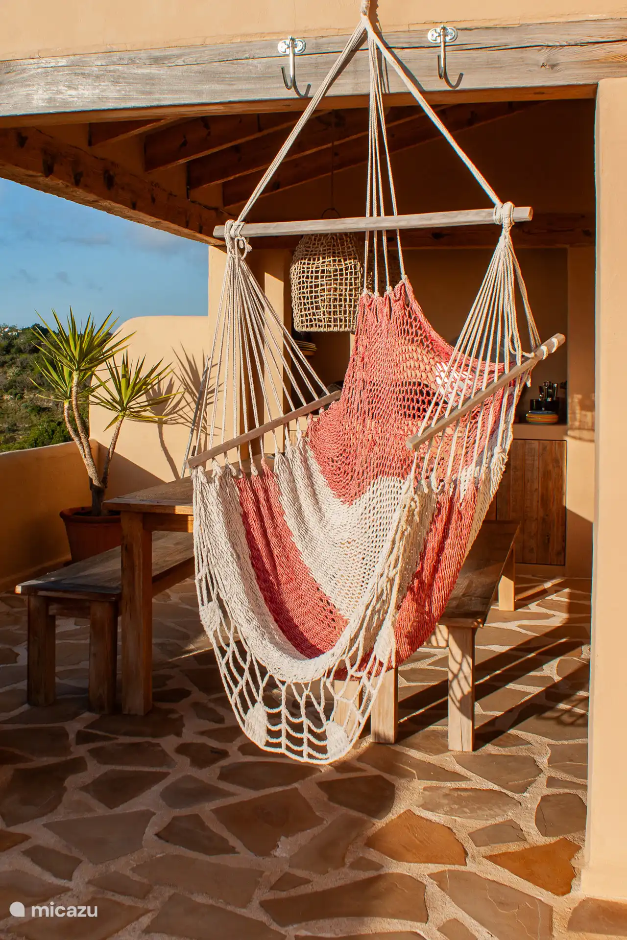 De schommelstoel waar je geniet van een prachtige zonsondergang.