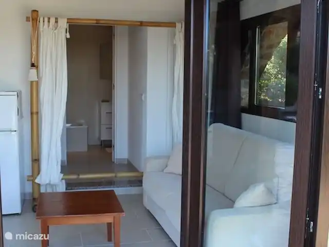 villa huren in Spanje, Costa Brava, Platja d'Aro – Villa met prachtig zeezicht en airco Openslaande deuren vanaf het zwembad terras naar de kleine zitkamer annex slaapbank van het benedenste gedeelte