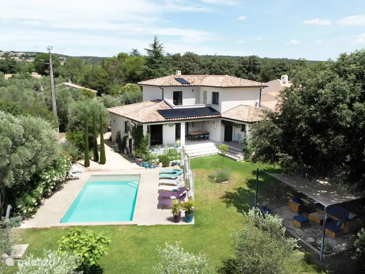 Luftaufnahme mit Swimmingpool (links), Haus und Lounge-Set (rechts) unter alter Eiche