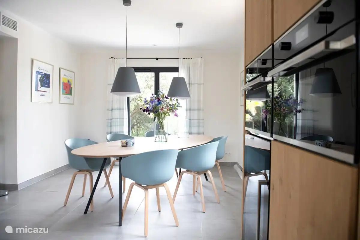 Essbereich mit 6 Stühlen und Küchengeräten (Backofen, Mikrowelle/Backofen und Weinkühler) auf der rechten Seite