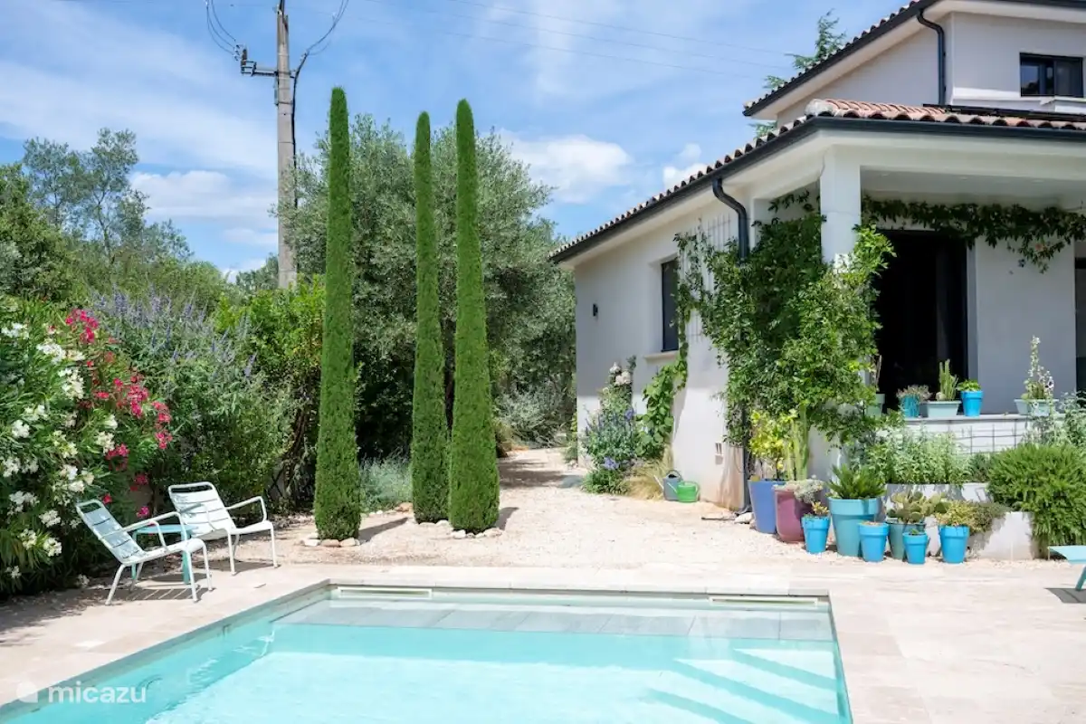 Blick vom Swimmingpool auf den Garten und den Durchgang zum Eingang und Parkplatz
