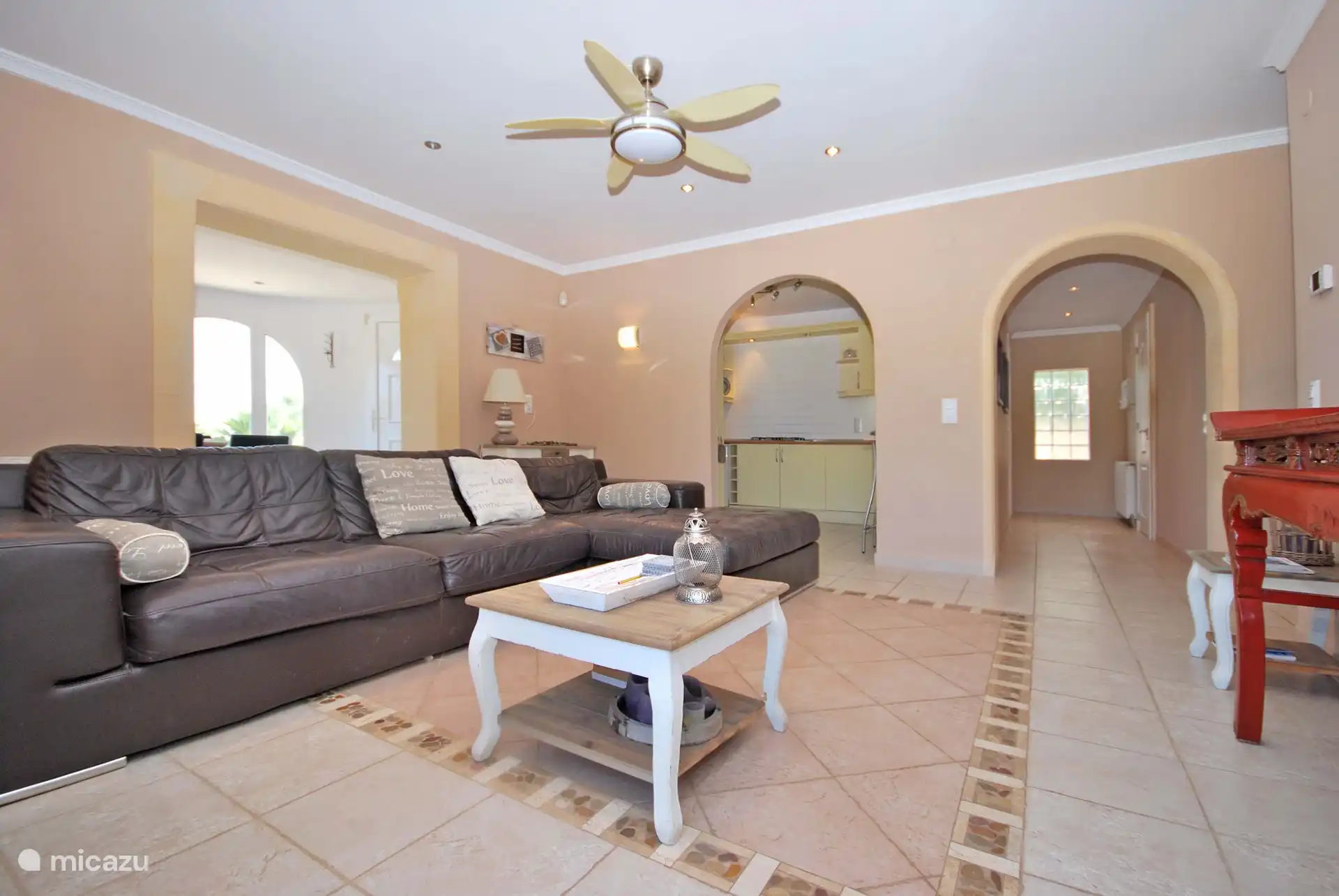 Salon spacieux au rez-de-chaussée avec télévision et porte donnant sur la terrasse de la piscine