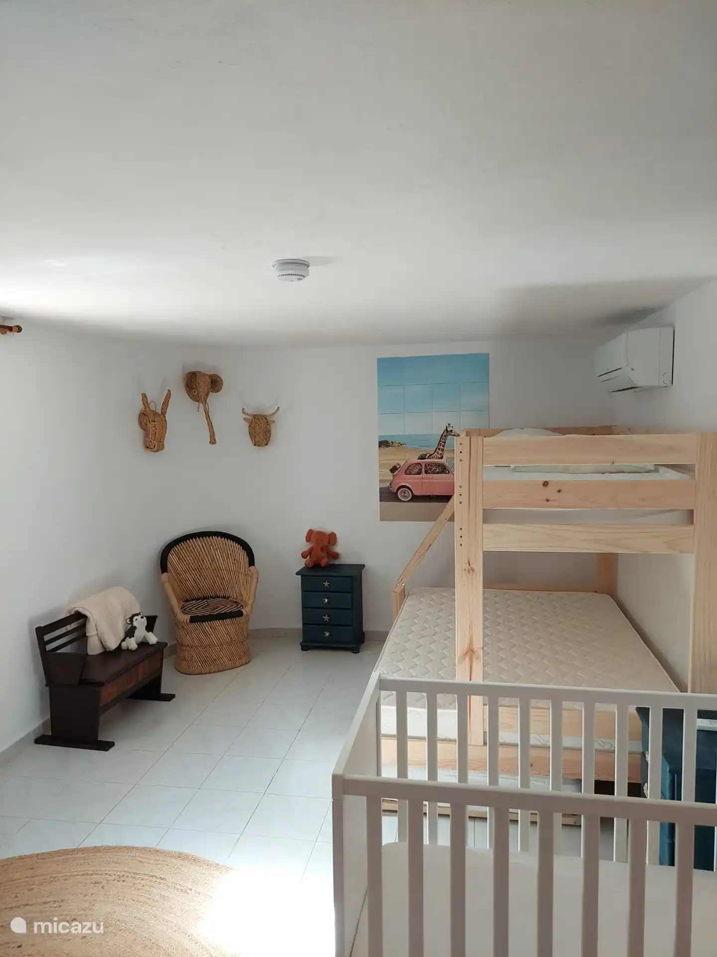 Slaapkamer met stapelbed, twijfelaar formaat voor het onderste bed, een uitschuifmatras en ledikant op de begane grond. 