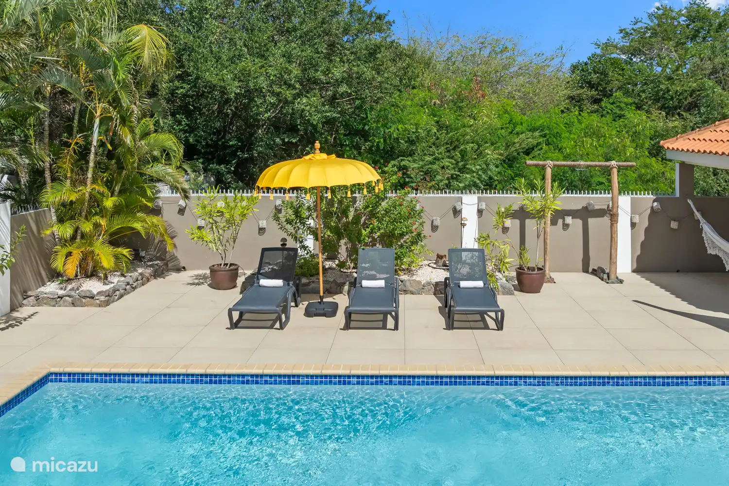 Mit Sonnenliege und einer Außendusche