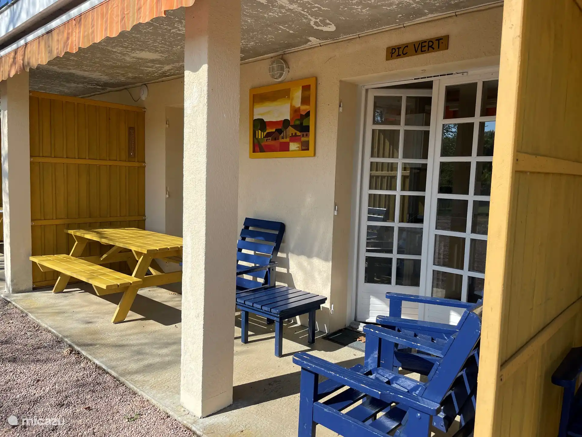 Entrada apartamento De Koekoek. Terraza cubierta con asientos