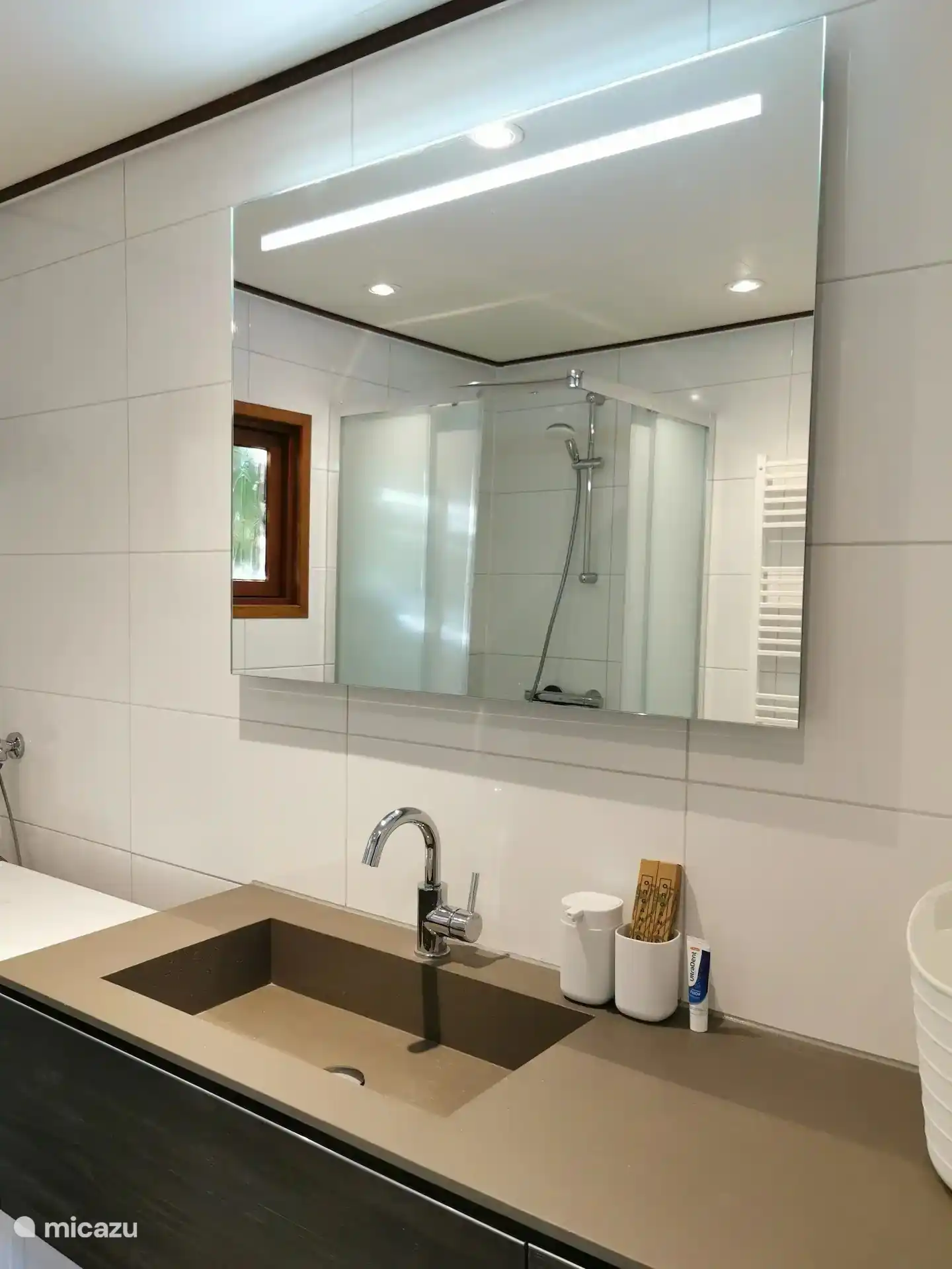 Modernes Waschbecken mit Heizung und Beleuchtung im Spiegel