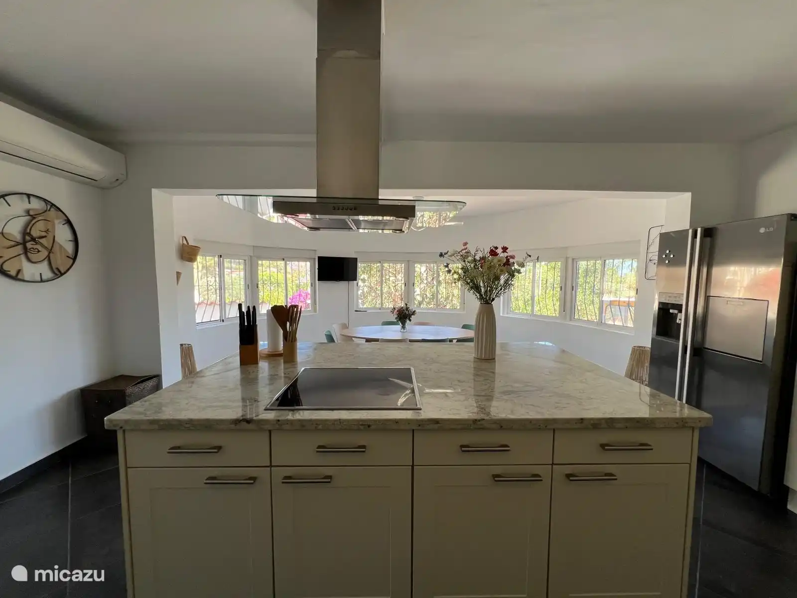 Vue de la cuisine et du frigo américain depuis l’îlot de cuisine. 