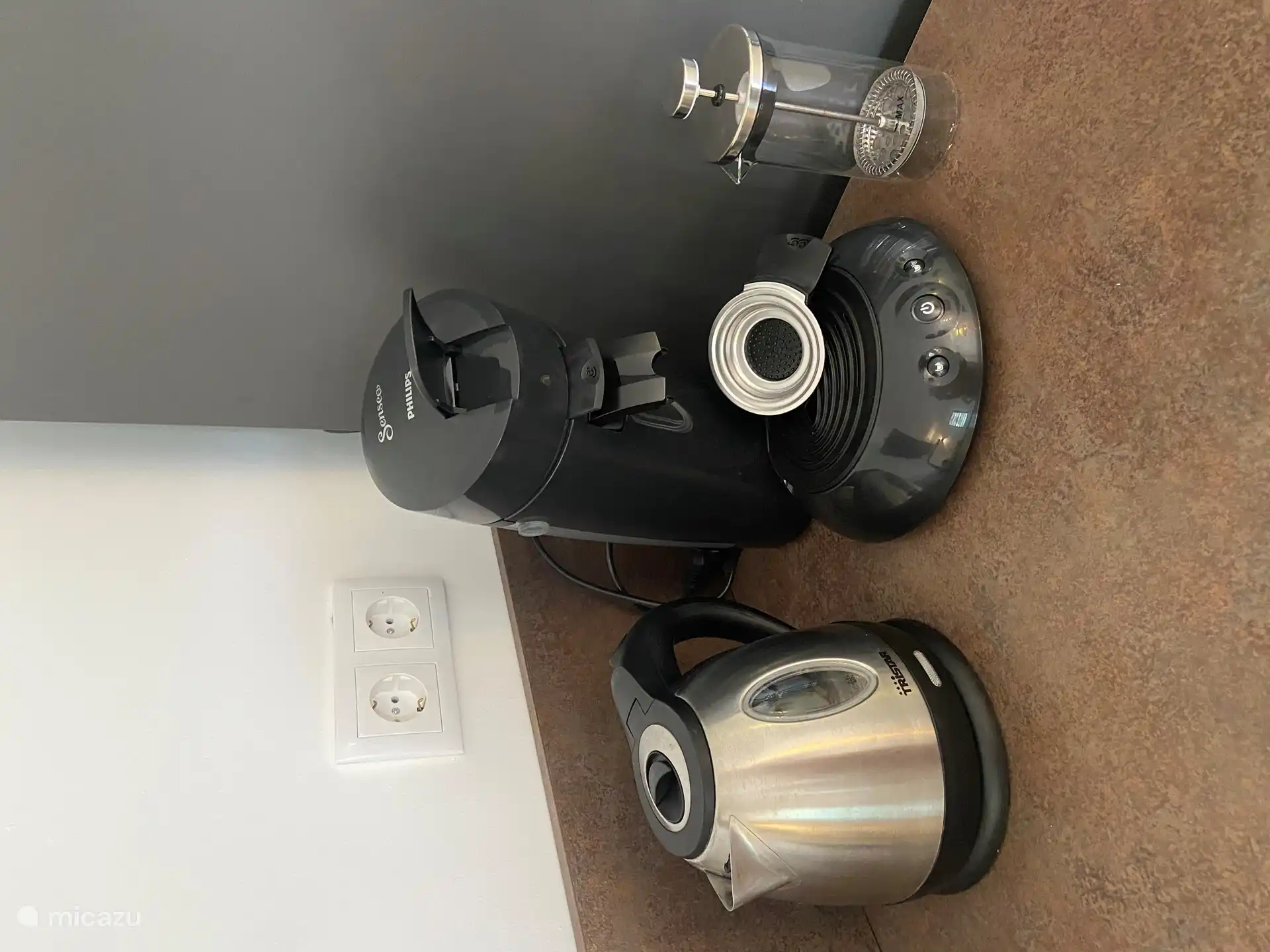 Keuken voorzien van waterkoker koffiezetapparaat met pads en een melkopschuimer.