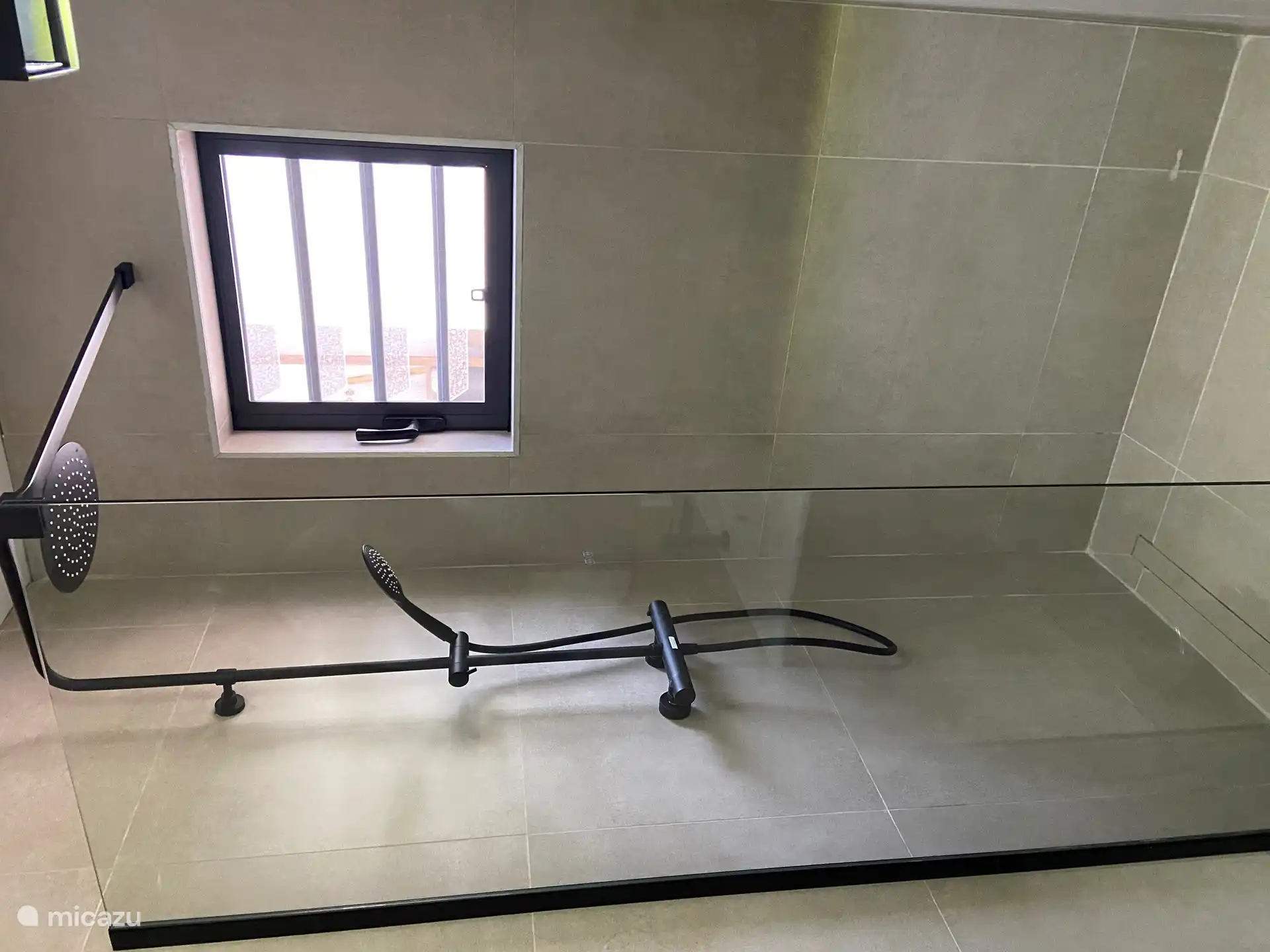 Douchehoek met regendouche en handdouche.