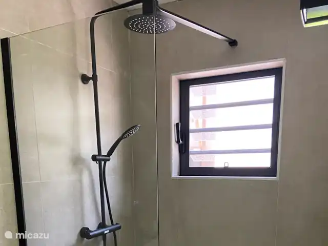 Location de Vacances Curaçao, Banda Ariba (est), Jan Thiel, appartement - Curalux Apartments-Flamingo Coin douche avec douche à effet pluie et douchette à main.