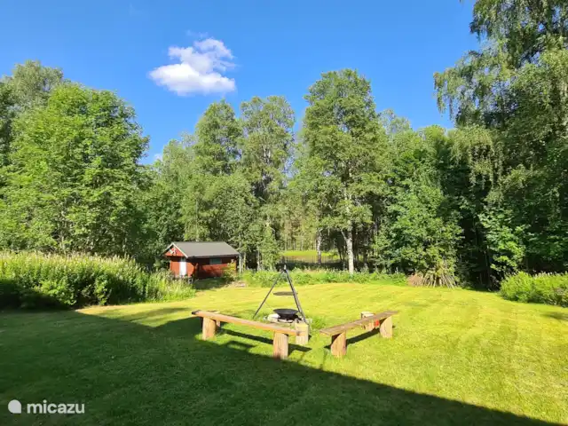 Älvsjö Anderssons en Suecia, Värmland, Lesjöfors - casa vacacional Zona de barbacoa con vistas al lago adyacente al jardín.