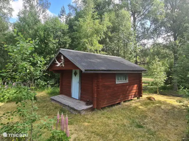 Älvsjö Anderssons en Suecia, Värmland, Lesjöfors - casa vacacional Cabaña de madera sueca en el jardín con varias camas sencillas.