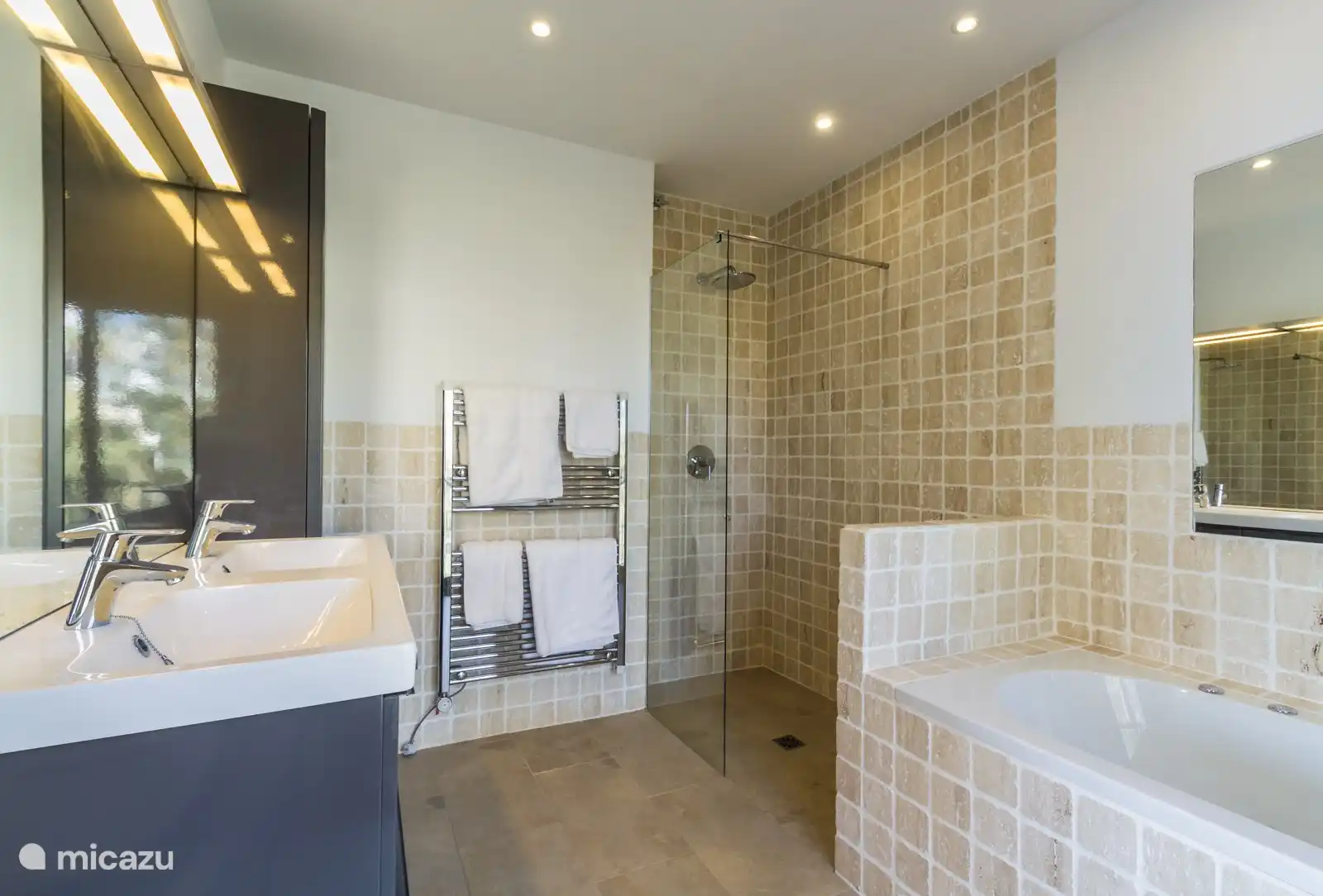 Badezimmer mit Badewanne, begehbarer Regendusche, Doppelwaschbecken und Toilette