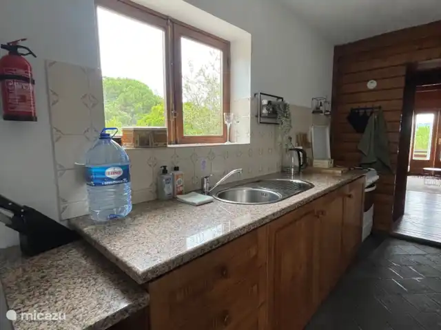 Location de Vacances Portugal, Coimbra, Covas, cabane en bois / lodge - Casa Vista Bonita La cuisine avec une cuisinière à gaz, et un cabanon à bois qui chauffe merveilleusement la maison