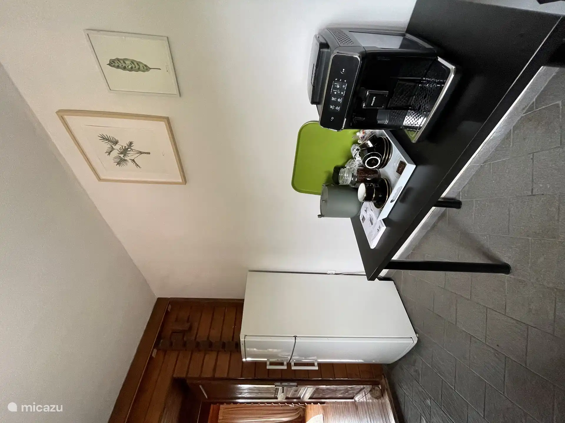 Küche mit Kühlschrank mit Gefrierfach und vollautomatischer Bohnenkaffeemaschine.