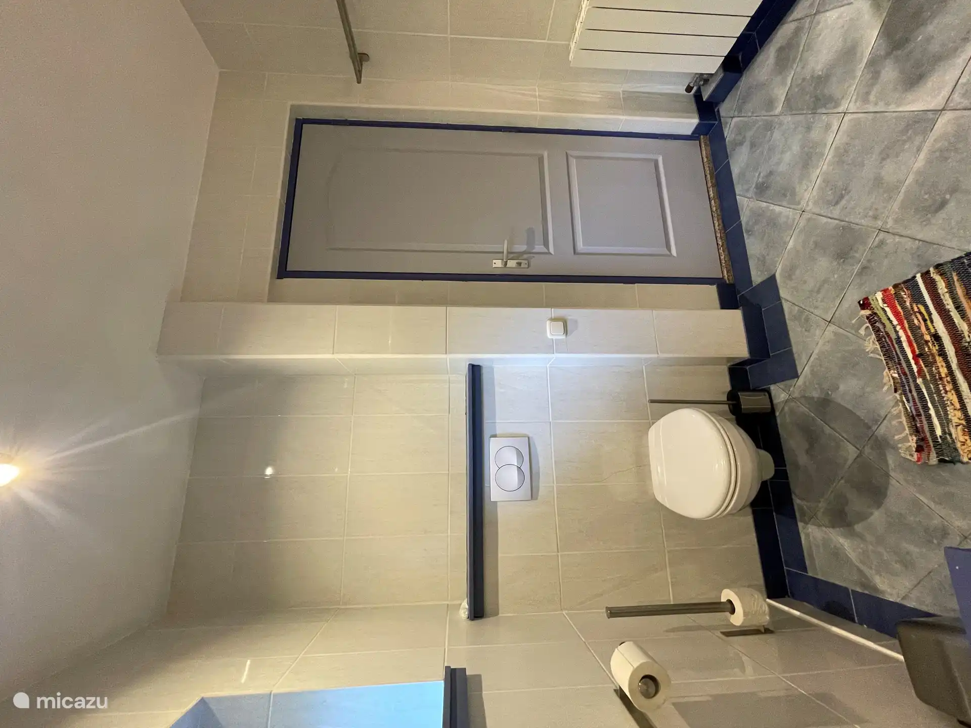 Das Badezimmer mit Tür zu einem kleinen Flur