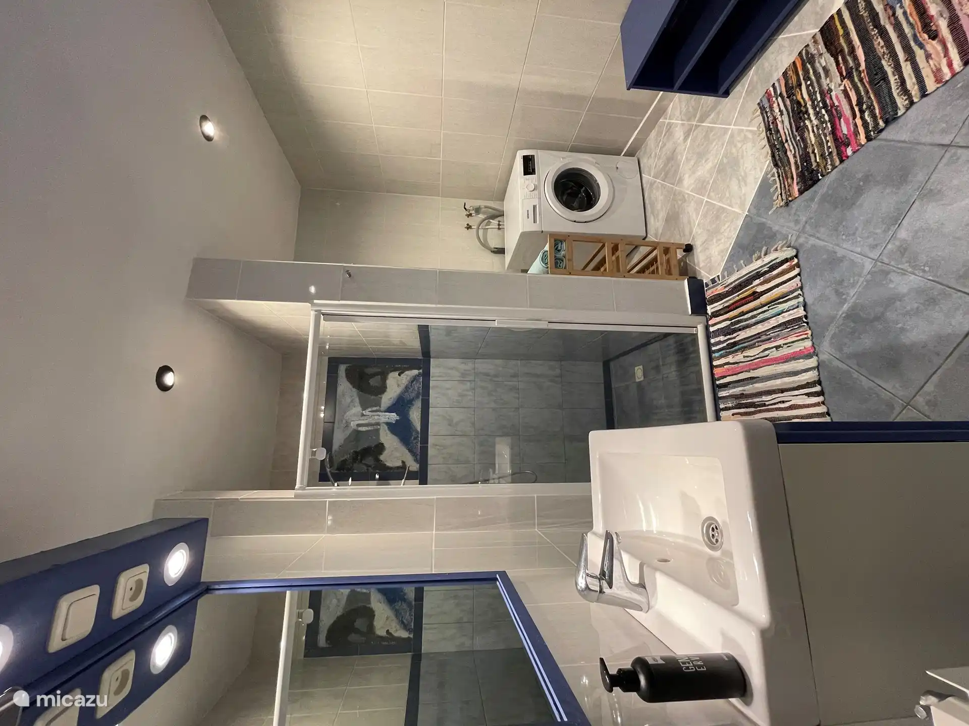 Das Badezimmer mit Dusche, Waschbecken, WC und Waschmaschine