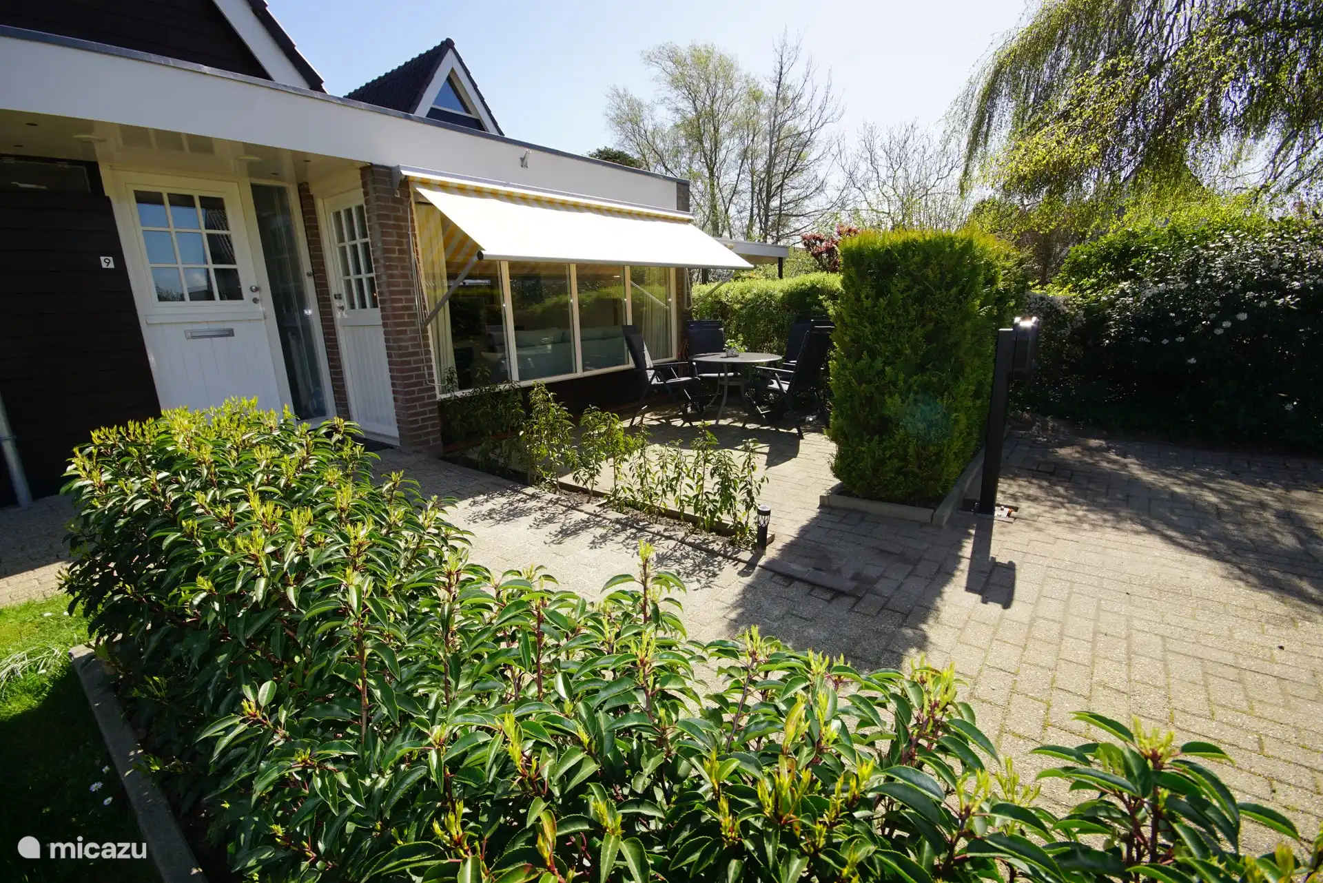 Het privé terras bij de studio met een tafel, 4 verstelbare stoelen en een kussenbox voor de stoelkussens.