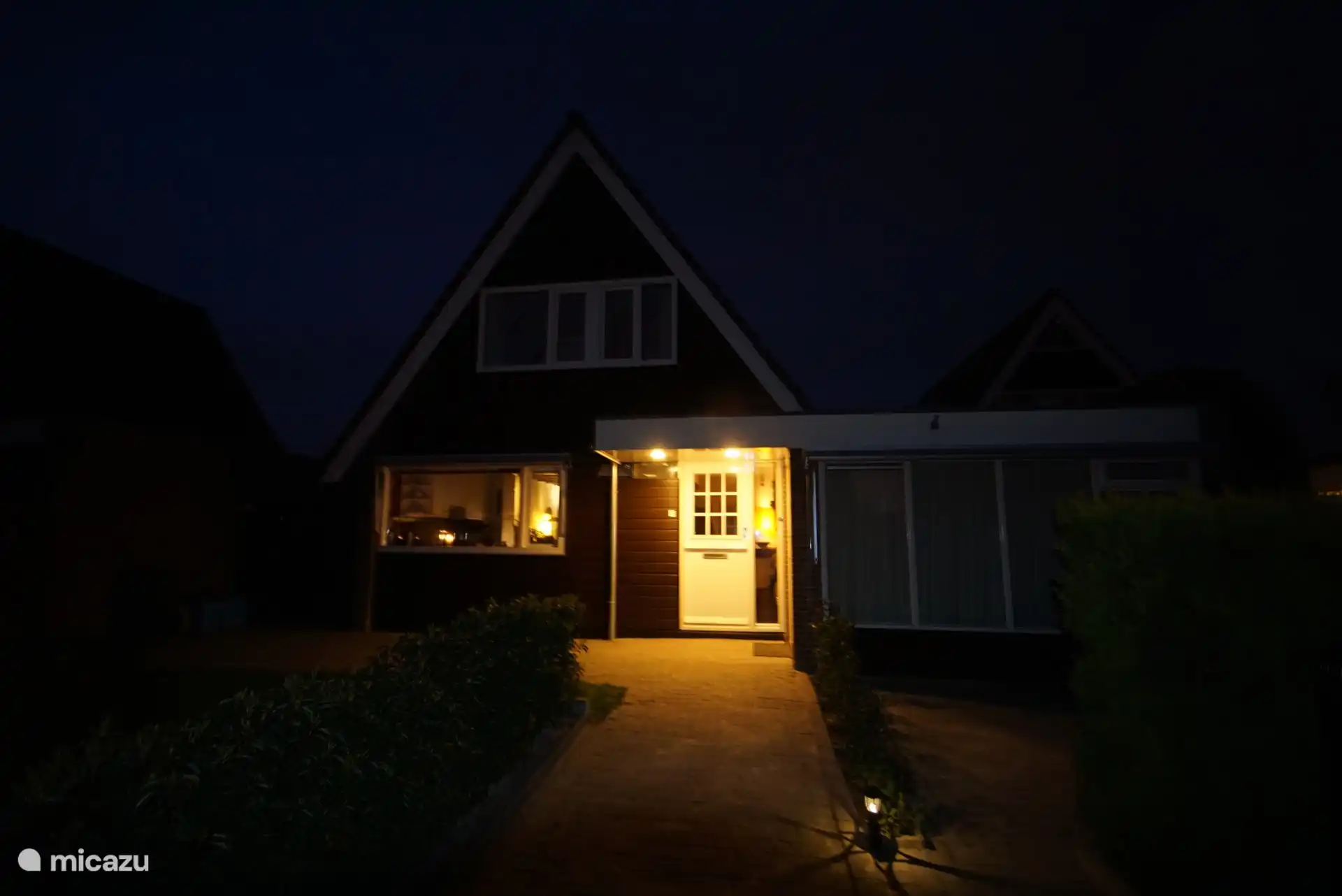 's Avonds is het pad naar de voordeur verlicht.