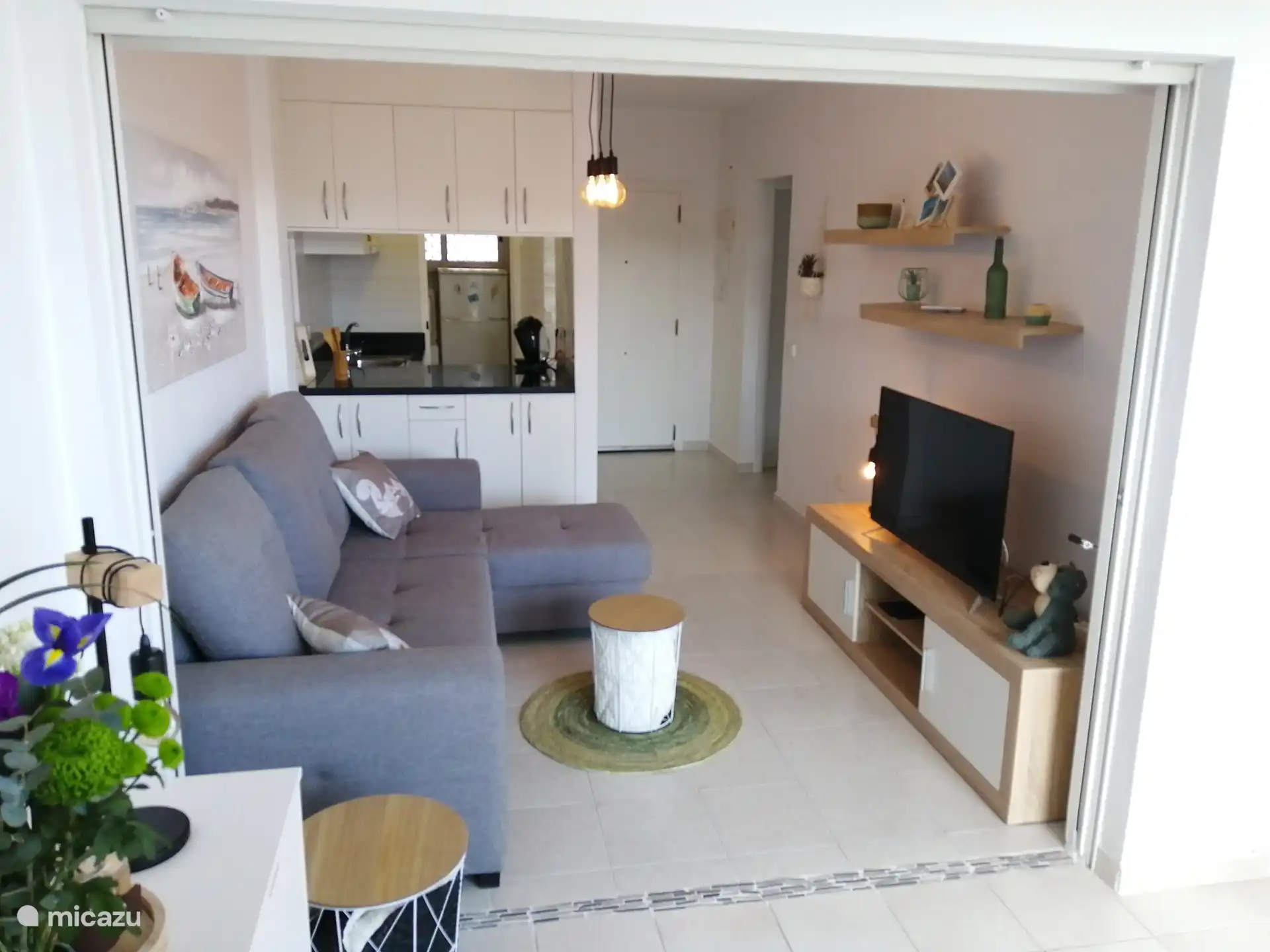 Vue du séjour vers la cuisine et la porte d'entrée.