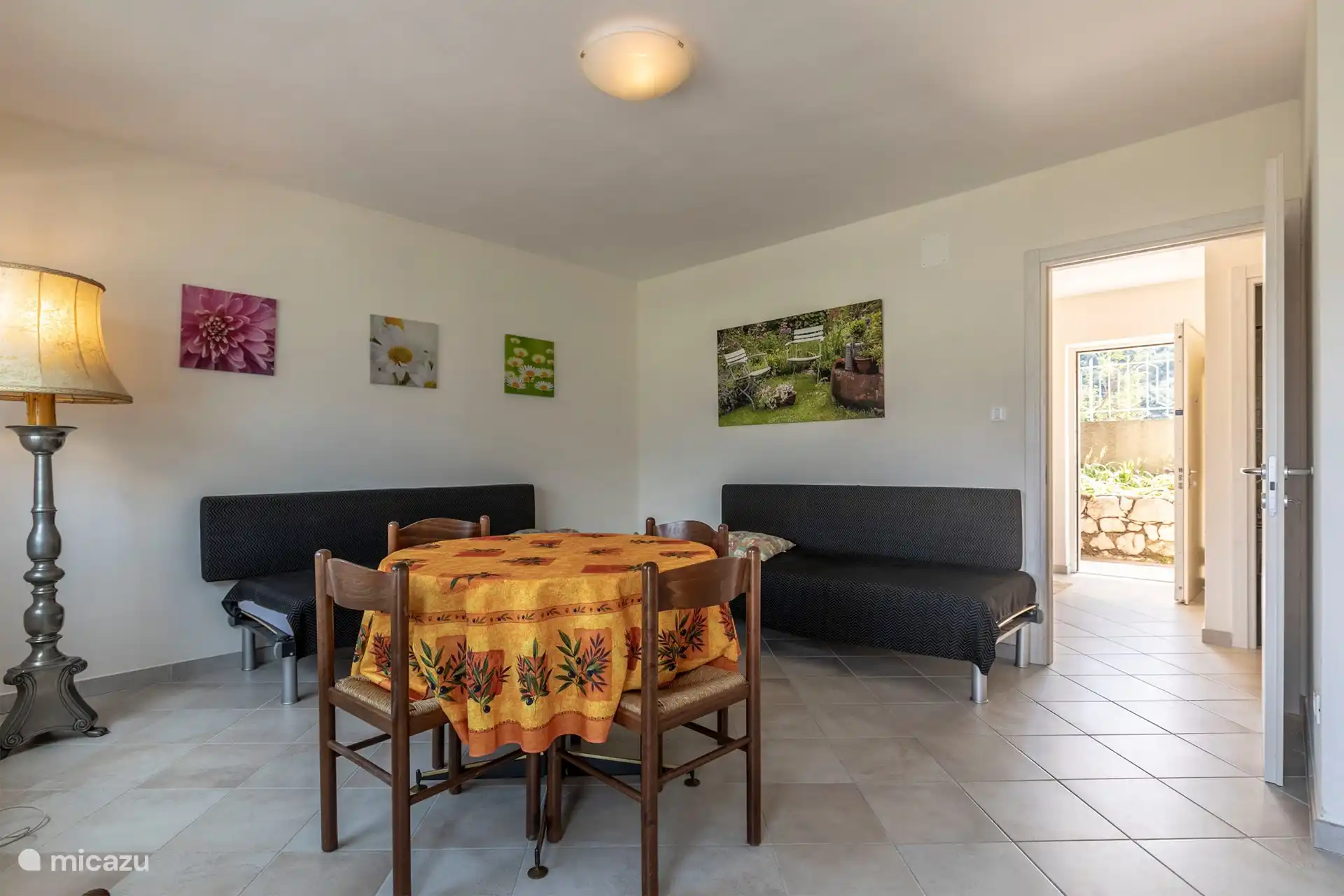 Espace de vie avec vue sur la porte d'entrée et terrasse le long de la façade.