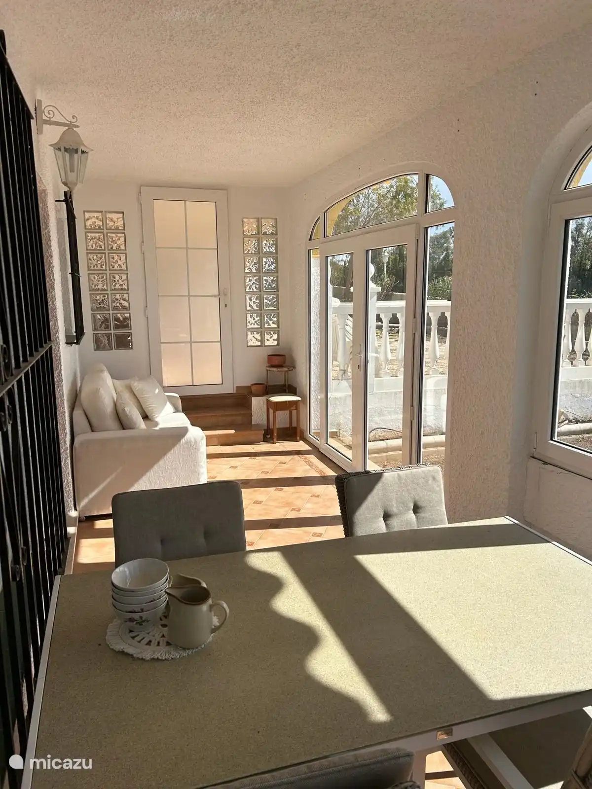 Überdachte Terrasse mit Terrassentüren der Wohnung.