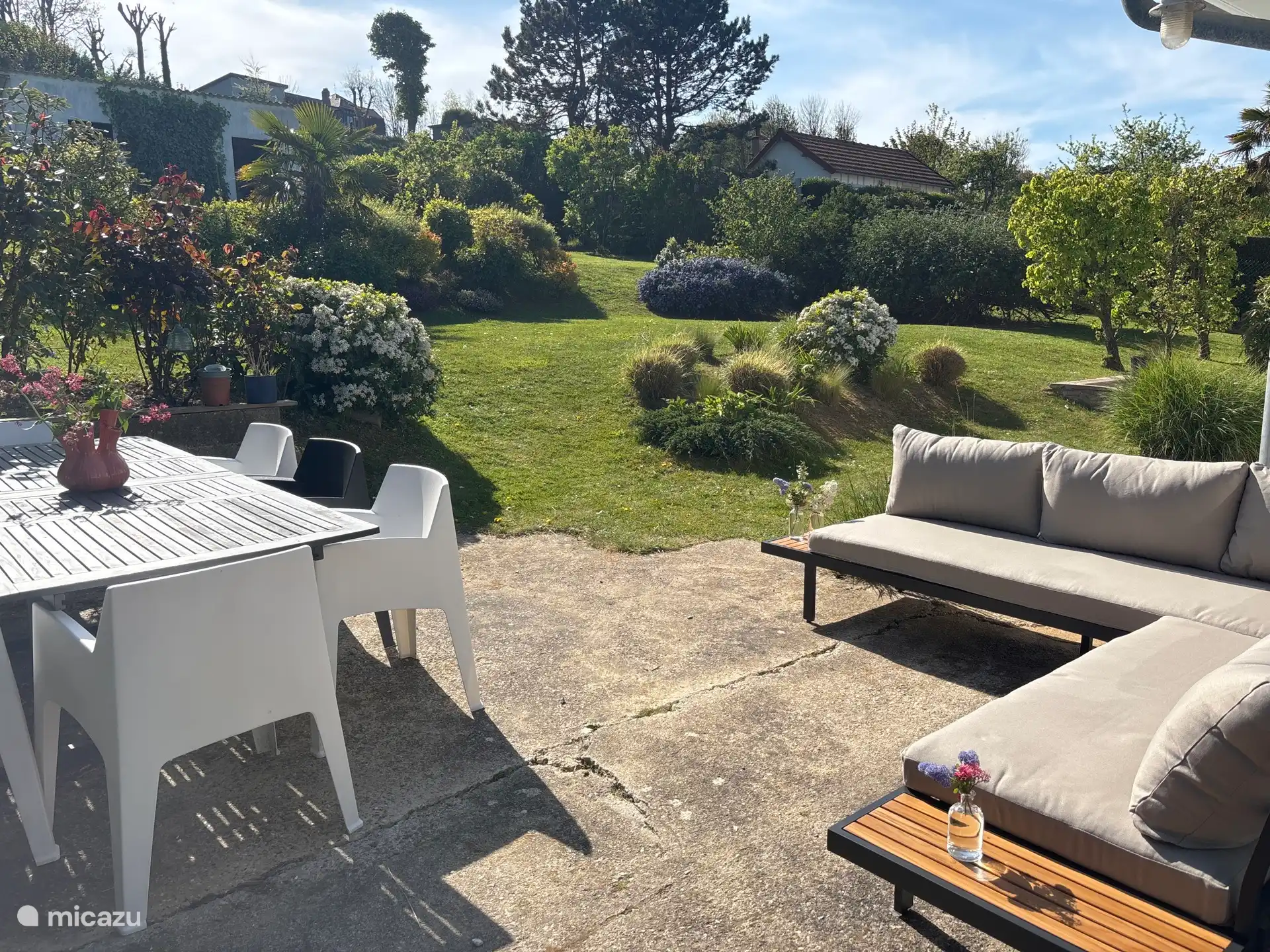 een gezellige tafel en lounge/borrelhoek geven uitzicht op een prachtige tuin