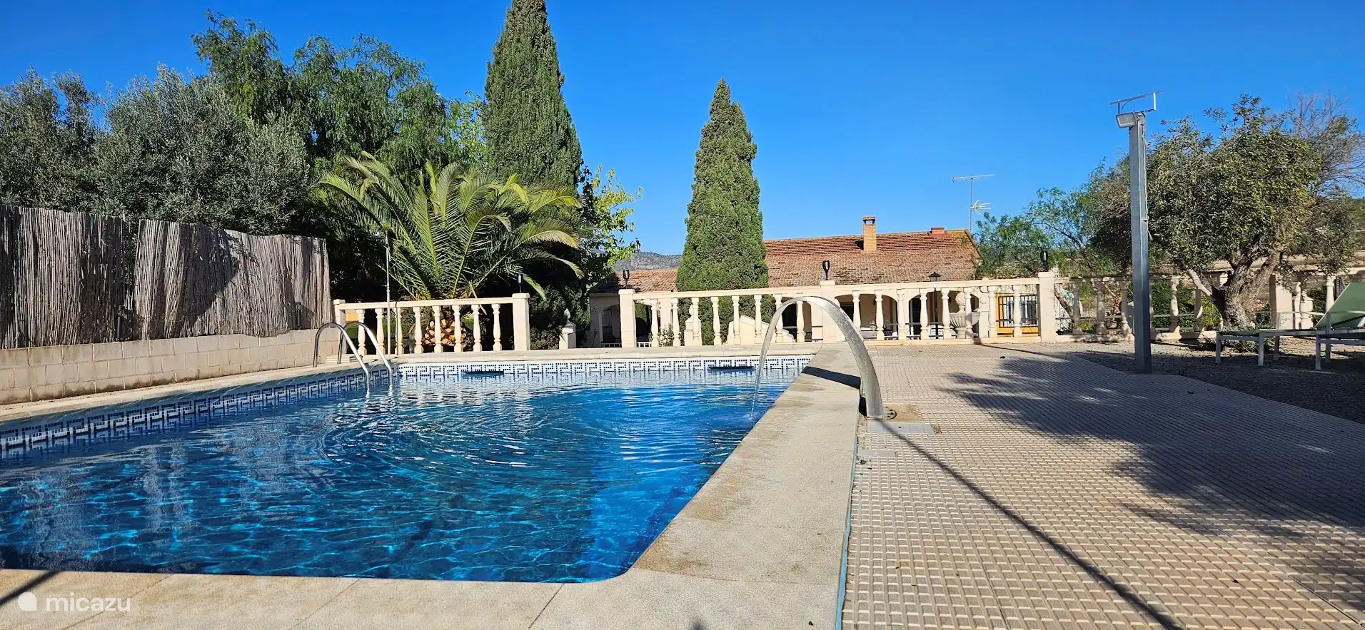 Zicht vanuit het zwembad naar het huis