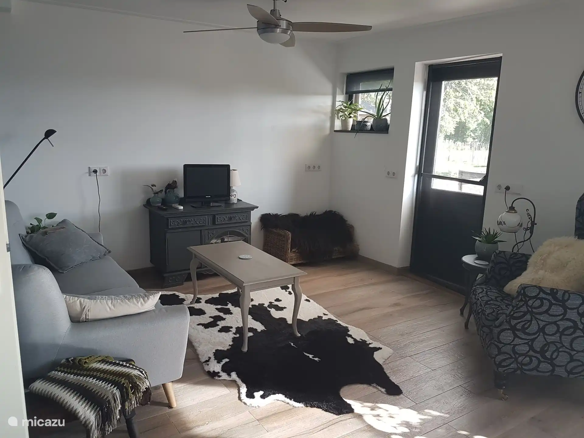 De woonkamer met de tv en deur naar het terras