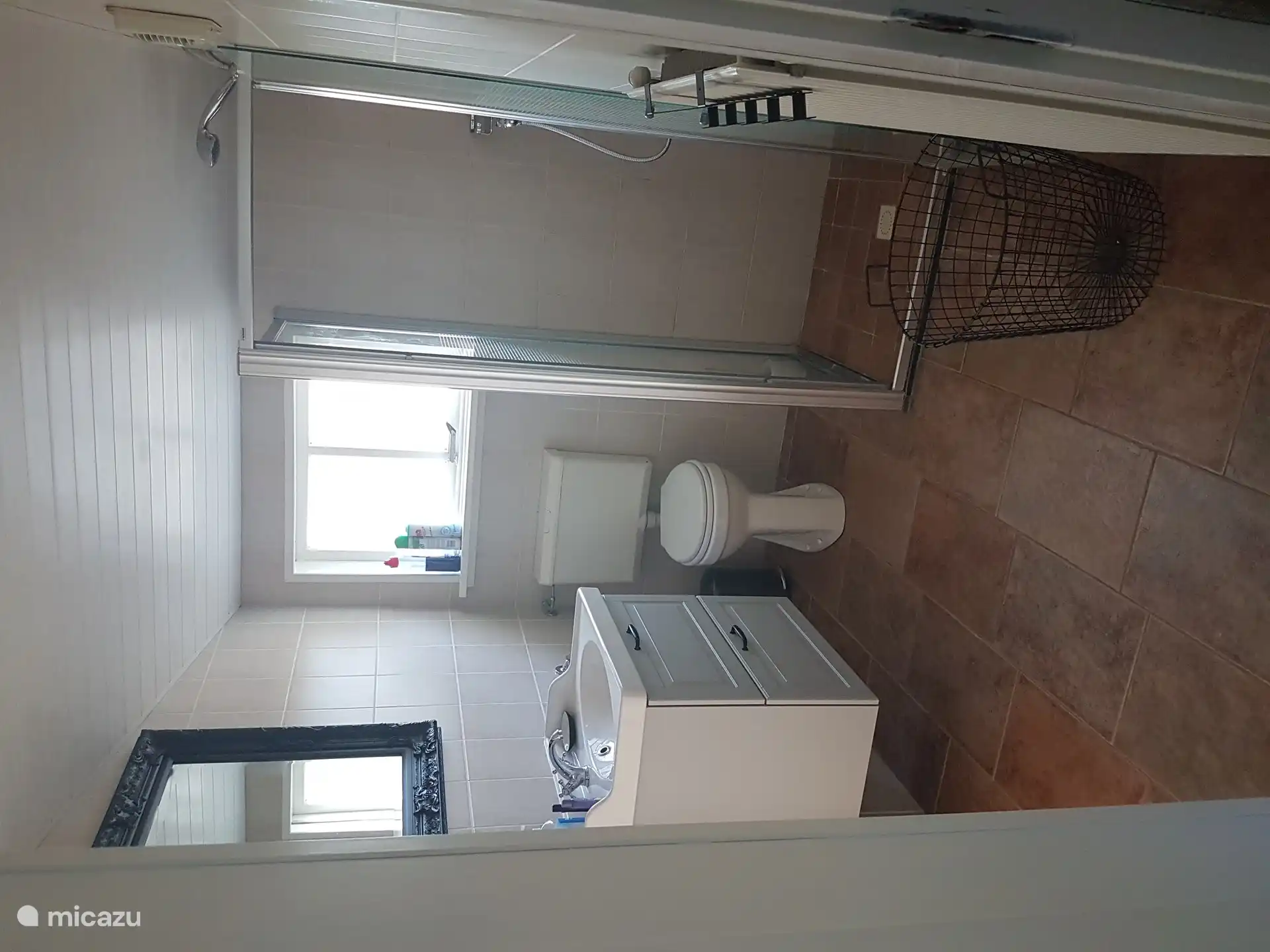 De badkamer met douche, wastafel en toilet