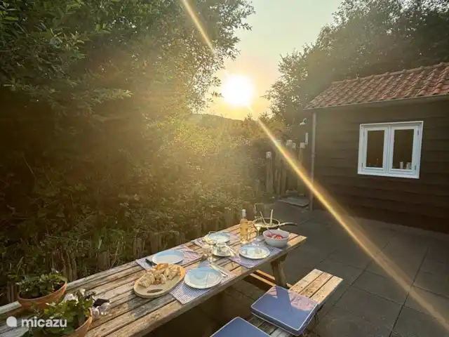 Duinbries huren in Nederland, Zeeland, Dishoek - vakantiehuis S'avonds buiten, tijdens het avondeten  op het terras, is er een prachtige zonsondergang te aanschouwen die achter de duinen verdwijnt.
