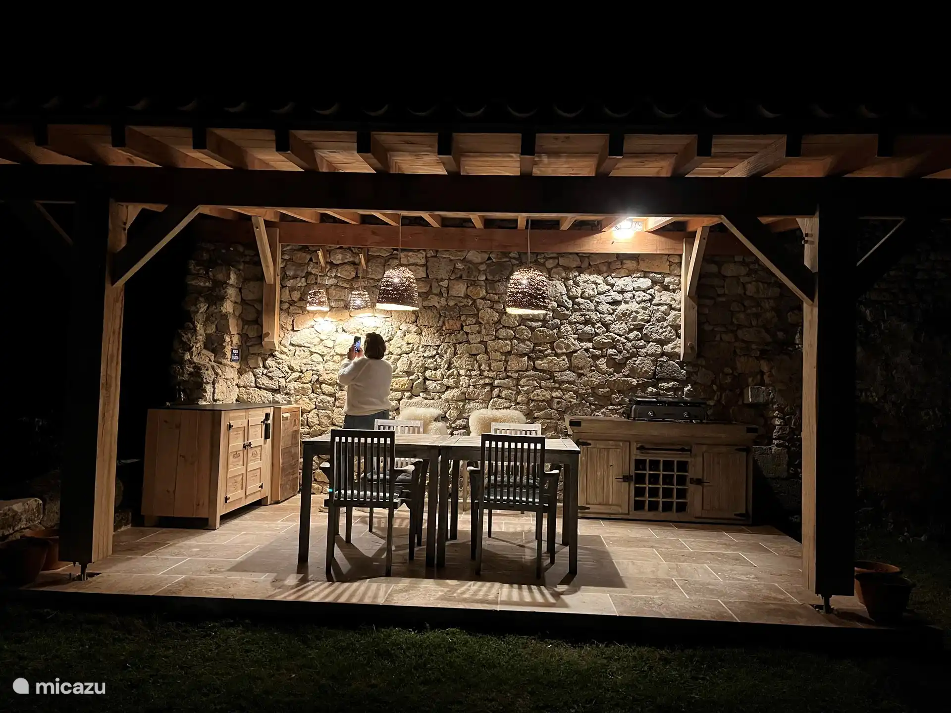 Cocina exterior cubierta con plancha, barbacoa y frigorífico.