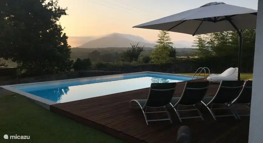 Schwimmbad mit Terrasse bei Einbruch der Dunkelheit