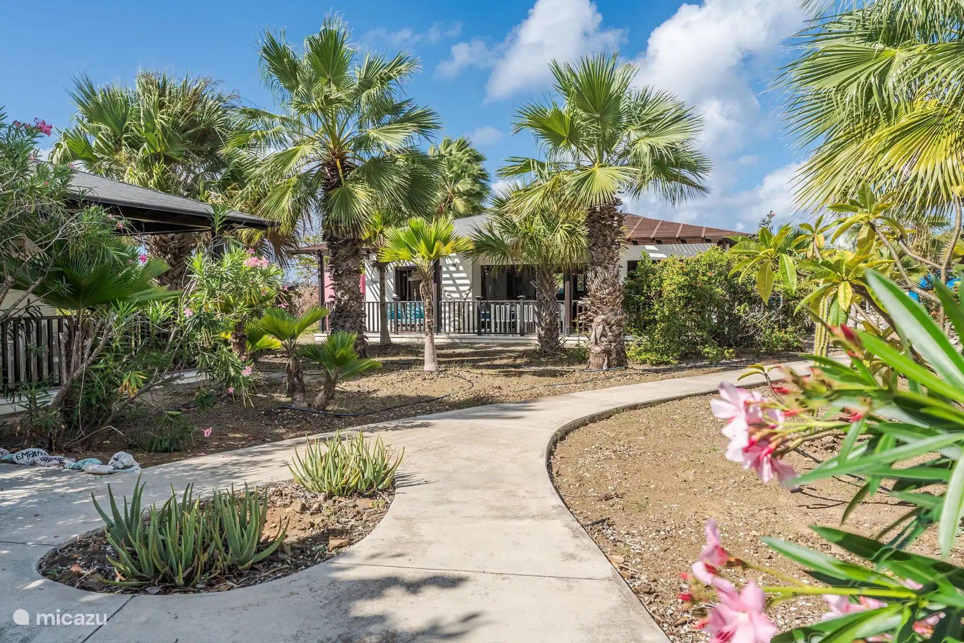 La maison, située dans un jardin tropical.